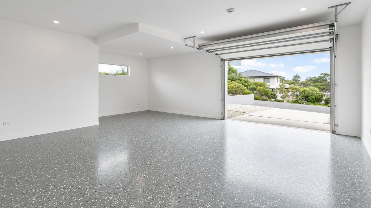 Illustrative example of a glossy grey flake epoxy floor in a bright, empty double garage